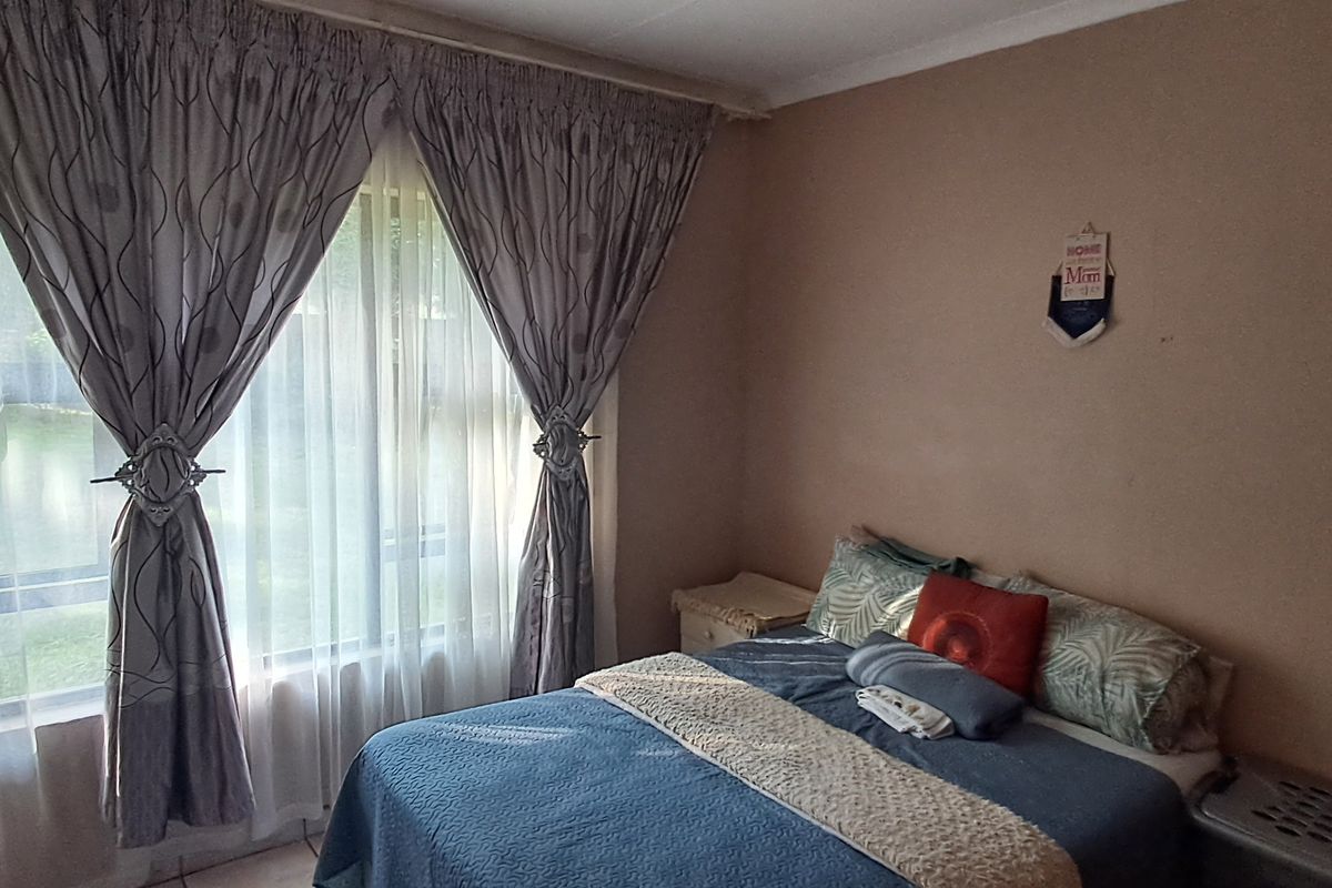 A standard bedroom featuring a large window that allows for natural light, providing a comfortable and functional living space.