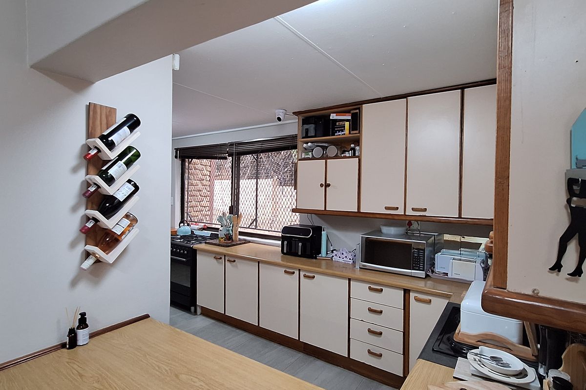 A functional kitchen featuring laminate cabinetry, a built-in stove, and a breakfast bar area with neutral finishes.