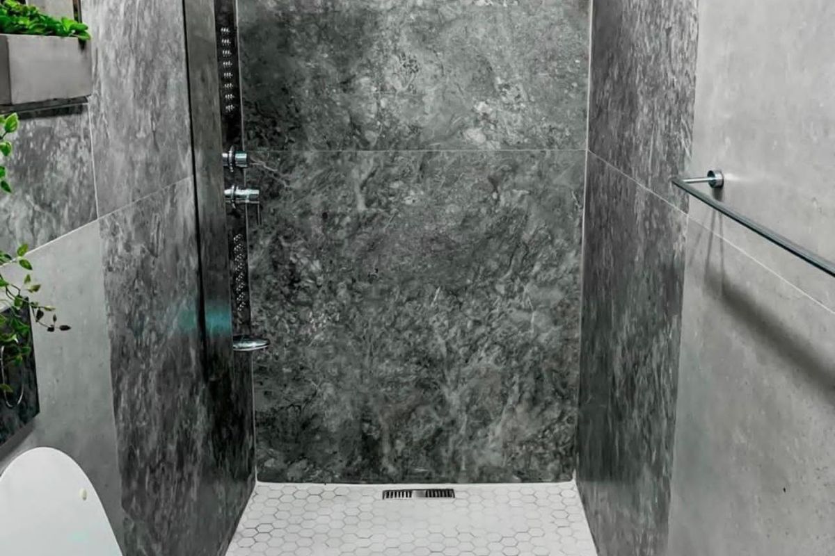 Modern bathroom featuring a walk-in shower with a rainfall shower head, marble-effect wall tiling, and hexagonal floor tiles.