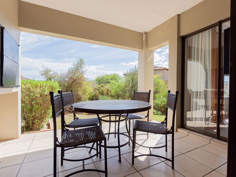 A covered patio area featuring tiled flooring and a large sliding glass door providing access to the interior living space.
