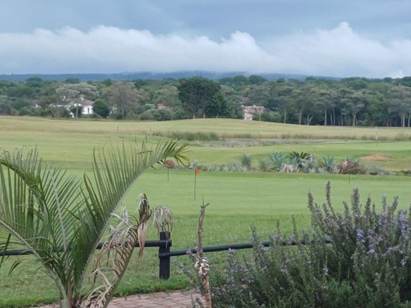 A scenic view overlooking a well-maintained golf course with lush green fairways and surrounding natural landscape.
