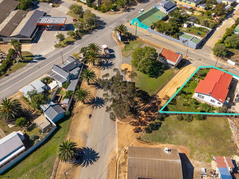 Aerial view of the property highlighting the building footprint, roof structure, and surrounding land parcel within the neighborhood context.
