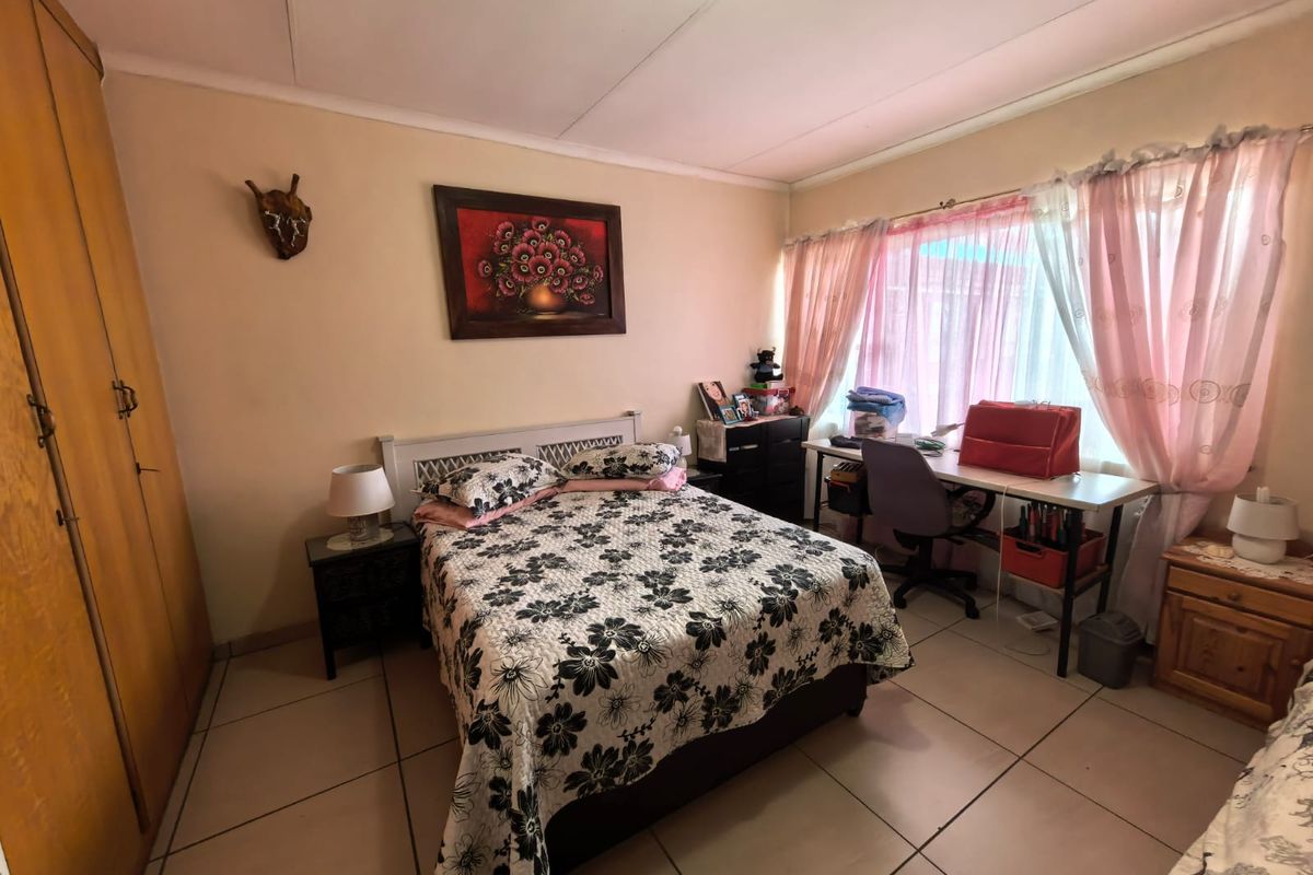 A functional bedroom featuring tiled flooring and a built-in wardrobe, offering a practical layout with natural light from the window.
