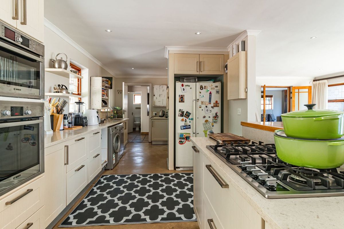 A functional kitchen featuring light-toned cabinetry, built-in double ovens, a gas cooktop, and a seamless transition to the adjacent living area.