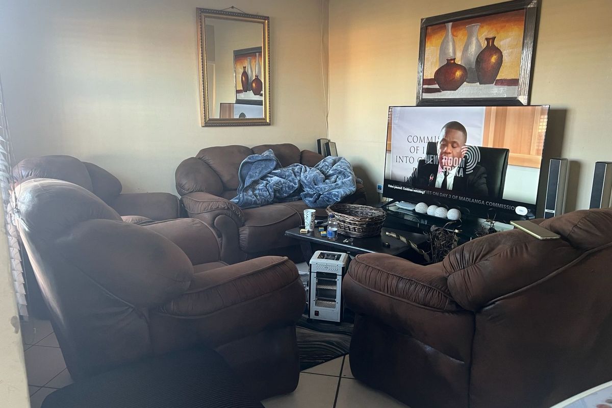 A comfortable living room featuring tiled flooring and neutral wall finishes, providing a functional space for relaxation and entertainment.