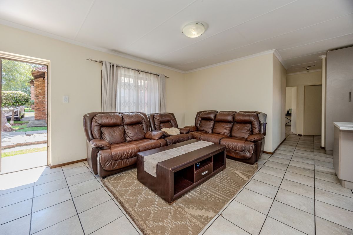 A functional living room area featuring tiled flooring and direct access to the exterior through a sliding door.