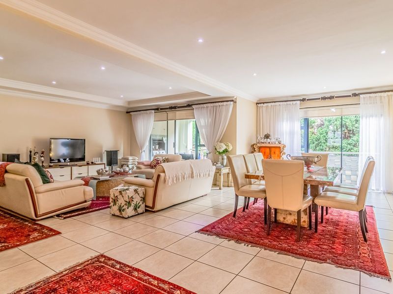 Spacious open-plan living and dining area featuring tiled floors, recessed lighting, and large sliding glass doors providing access to the outdoor space.