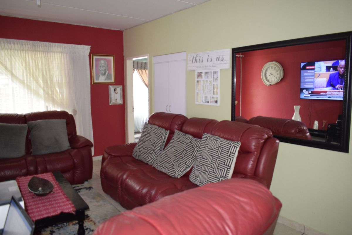 A living room area featuring a built-in cupboard and neutral wall finishes, providing a functional space for relaxation.