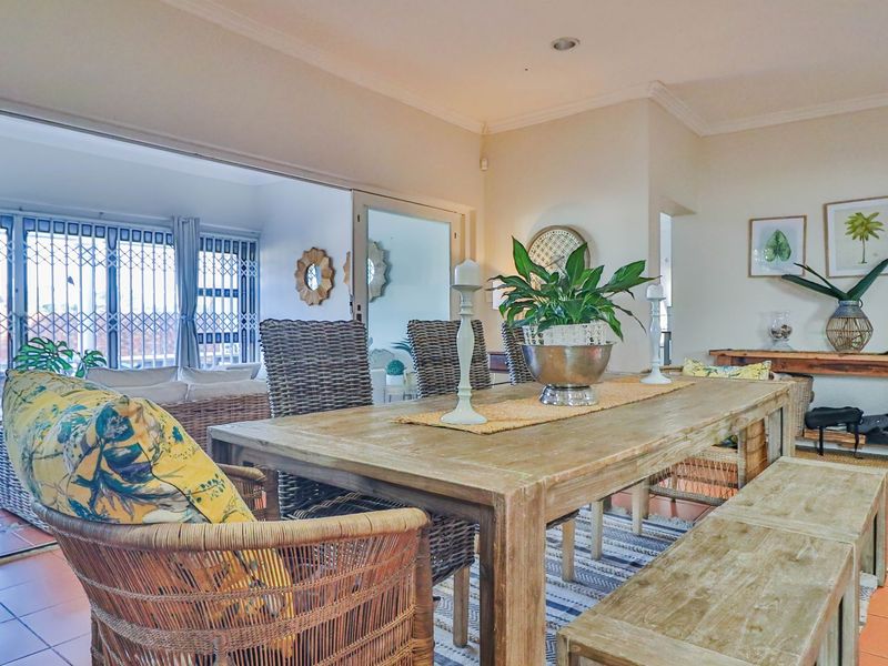 Open-plan dining area featuring terracotta floor tiles and large sliding glass doors leading to an outdoor patio space.
