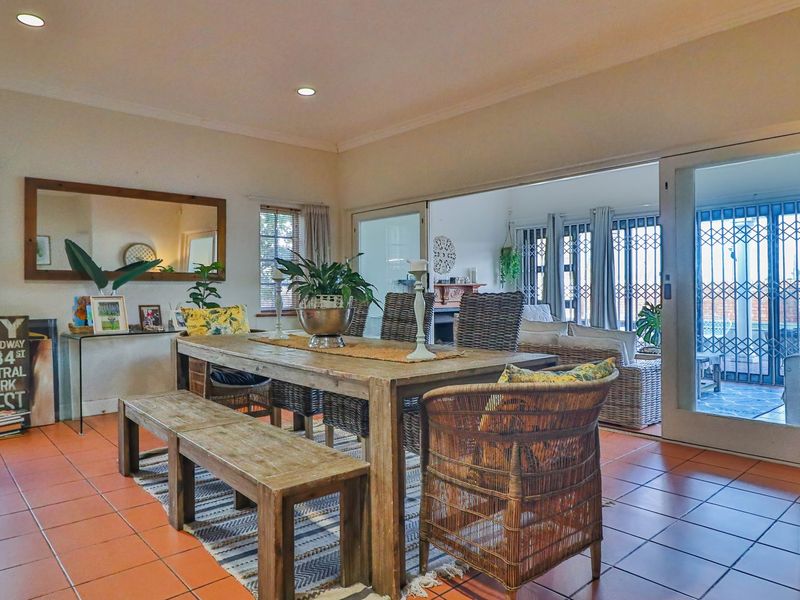Spacious dining area featuring terracotta floor tiles and large sliding glass doors providing seamless access to the outdoor patio area.