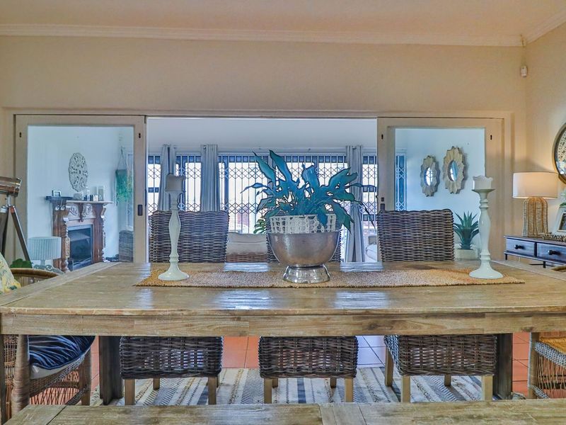 A dining area featuring tiled flooring and sliding glass doors that open into an adjacent living space with a fireplace.
