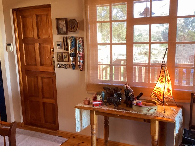 An entry area featuring warm timber flooring, a classic timber panel door, and a large window with natural light.
