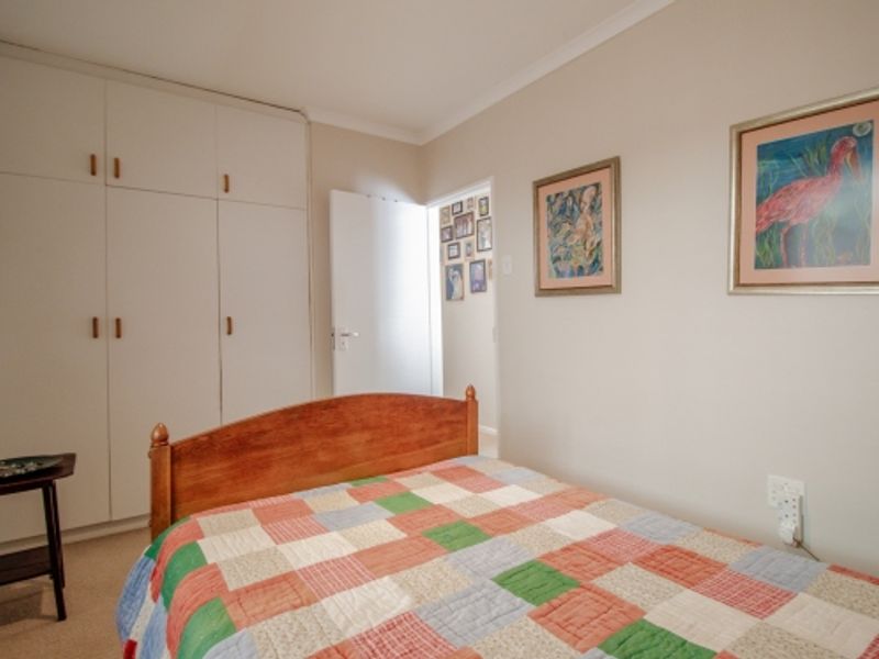A functional bedroom featuring built-in cupboards and neutral wall finishes, providing a comfortable and practical living space.