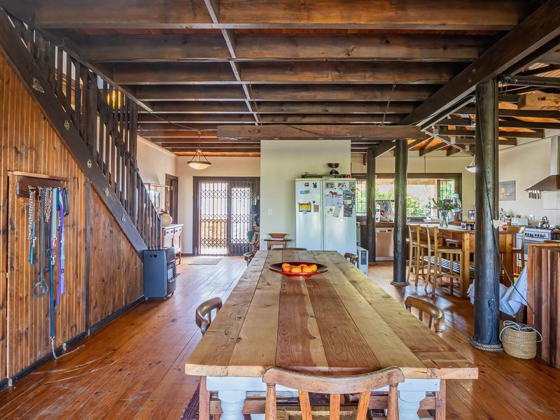 Spacious open-plan living and dining area featuring rustic timber ceilings, exposed beams, and integrated kitchen space with warm wood finishes throughout.