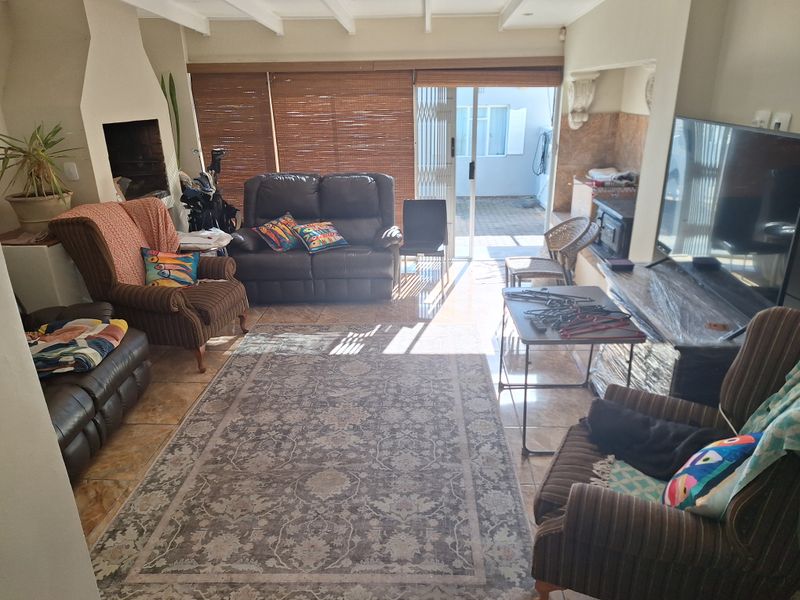 Spacious living room featuring tiled flooring, a built-in fireplace, and sliding glass doors providing direct access to the outdoor area.