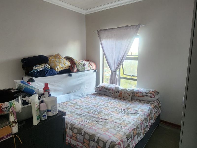 A functional bedroom featuring a built-in cupboard and a window, providing natural light and essential storage space.