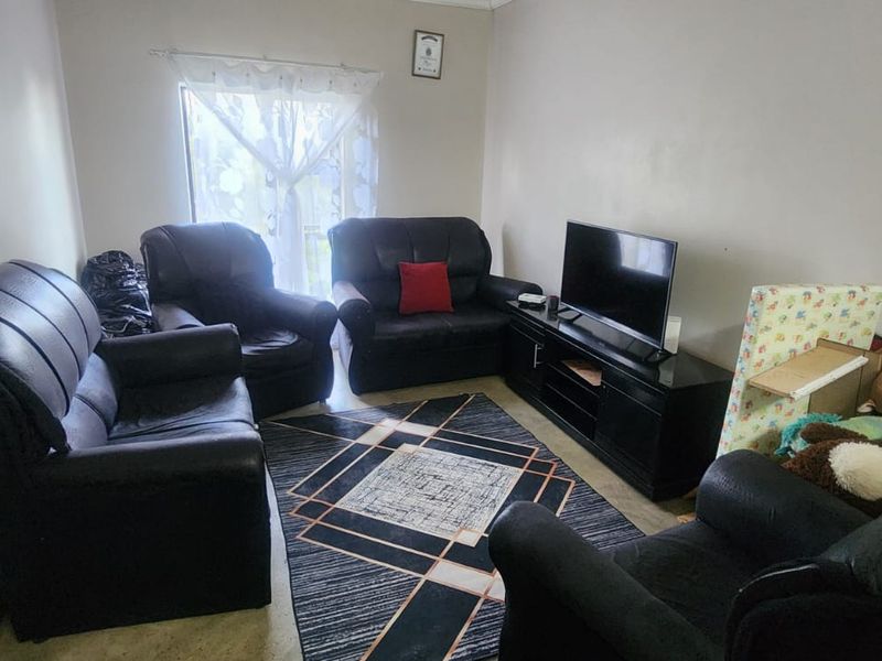 A living room area featuring a window and neutral wall finishes, providing a functional space for relaxation.