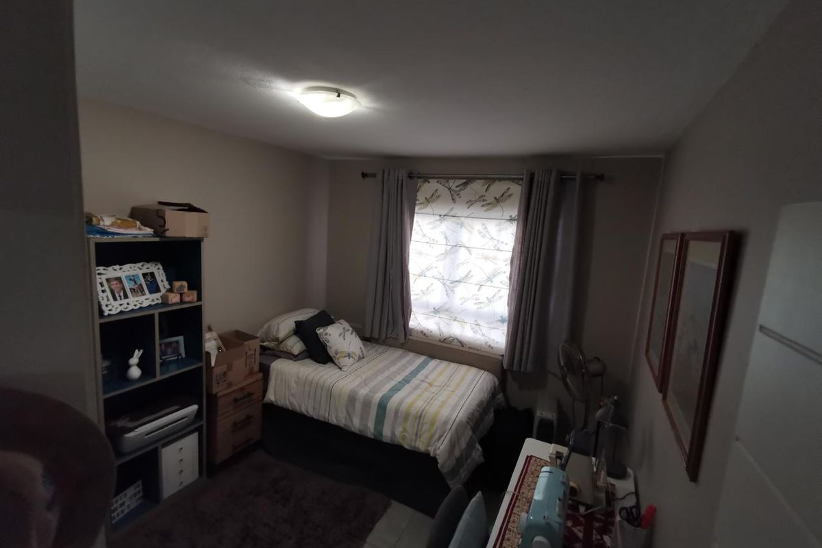 A standard bedroom featuring a window with curtain tracks and a central ceiling light fixture, providing a functional space for rest.