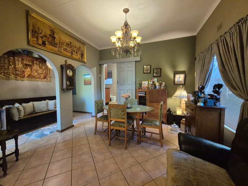 Dining room featuring ceramic tile flooring, an arched entryway, and a decorative chandelier, providing a classic and functional space for meals.