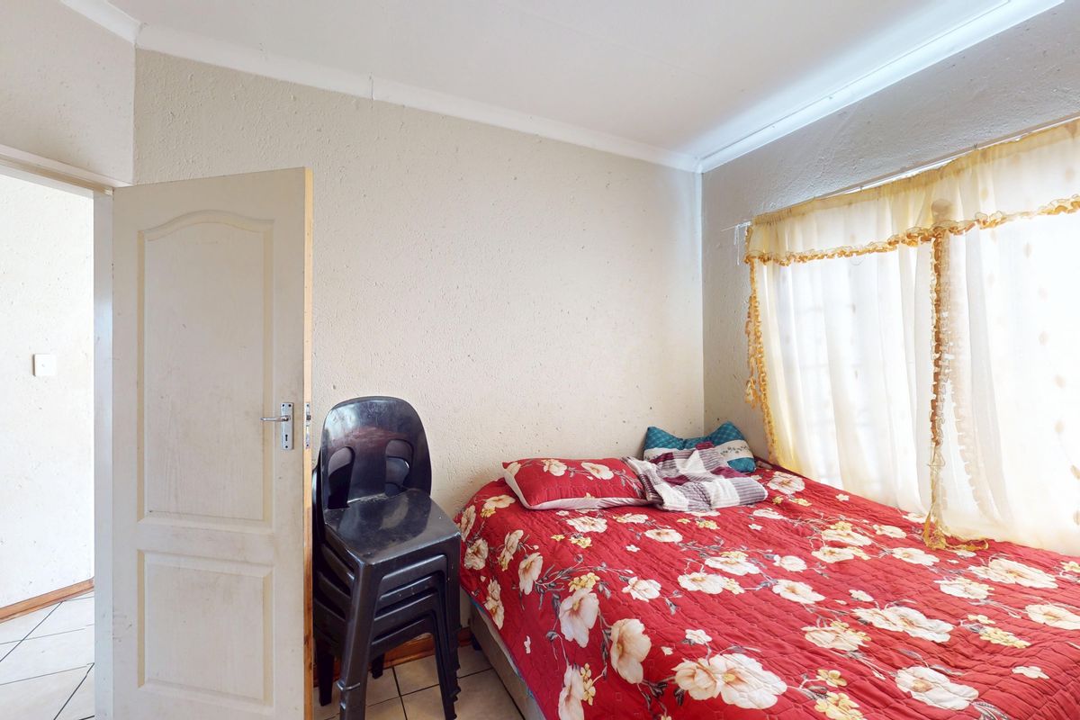 A bedroom featuring tiled flooring and a coved ceiling, offering a functional space ready for cosmetic updates and modern finishes.