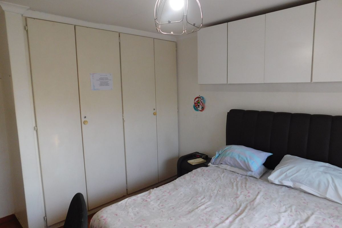 Bedroom featuring extensive built-in cupboard storage and additional overhead cabinetry, providing ample space for organization.