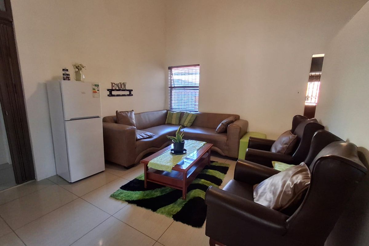 A living room featuring tiled flooring and venetian blinds, offering a functional space with neutral wall finishes.