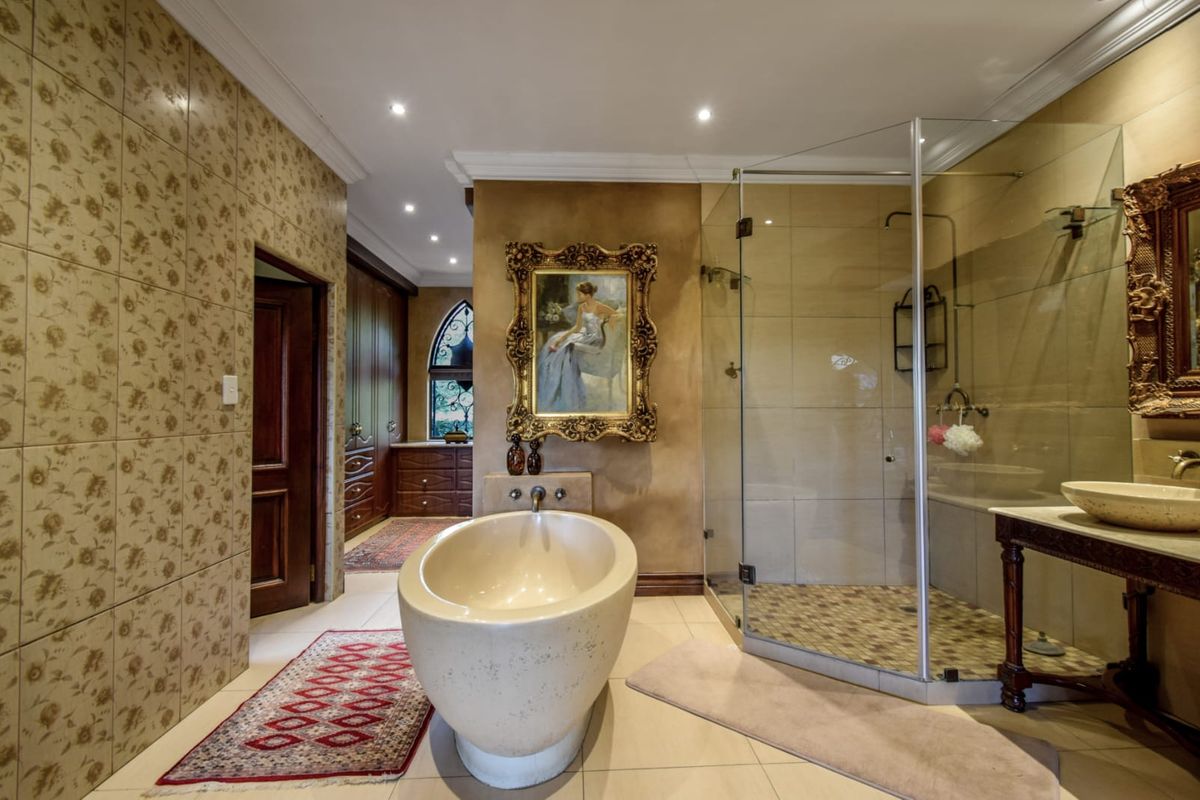 Spacious bathroom featuring a freestanding bathtub, glass-enclosed shower, vessel sink, and custom built-in cabinetry with elegant finishes.