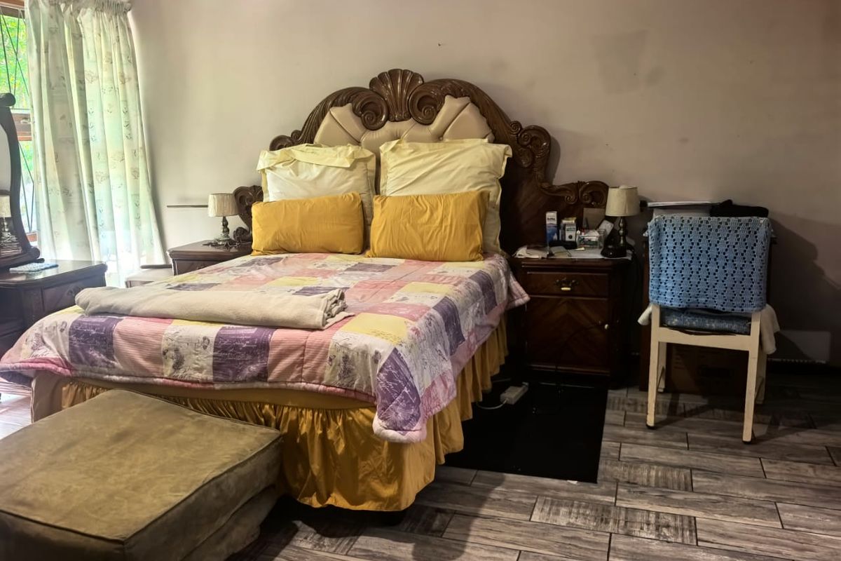 A bedroom featuring wood-look tile flooring and neutral wall finishes, providing a functional space ready for cosmetic updates.