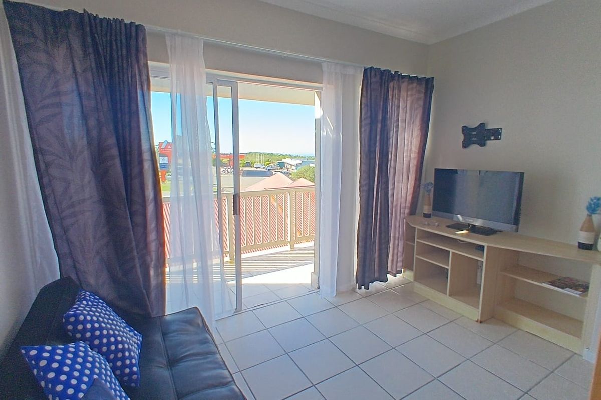 Living room featuring tiled flooring and a sliding glass door providing direct access to an outdoor balcony area.