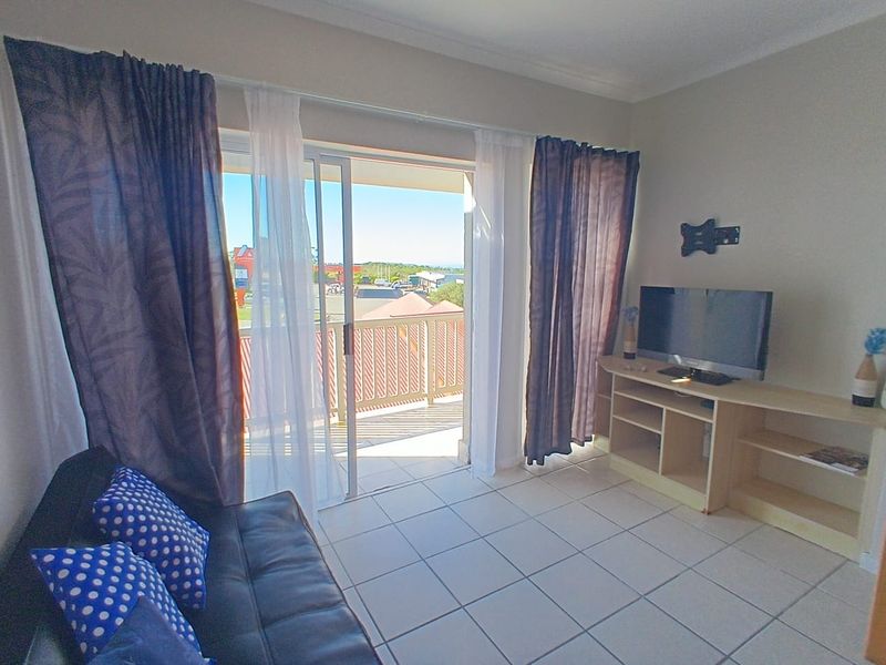 Living room featuring tiled flooring and a sliding glass door providing direct access to an outdoor balcony area.