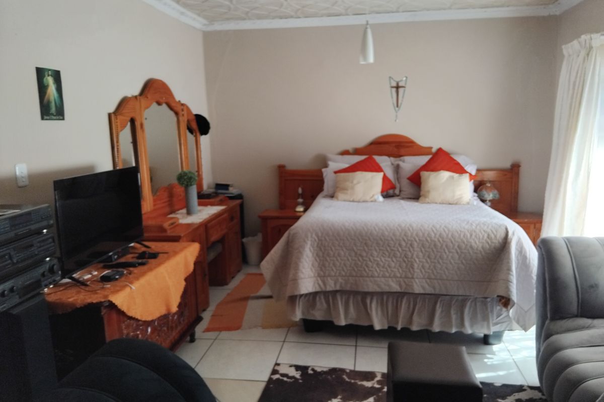 A bedroom featuring tiled flooring and a textured ceiling, providing a functional and lived-in space.