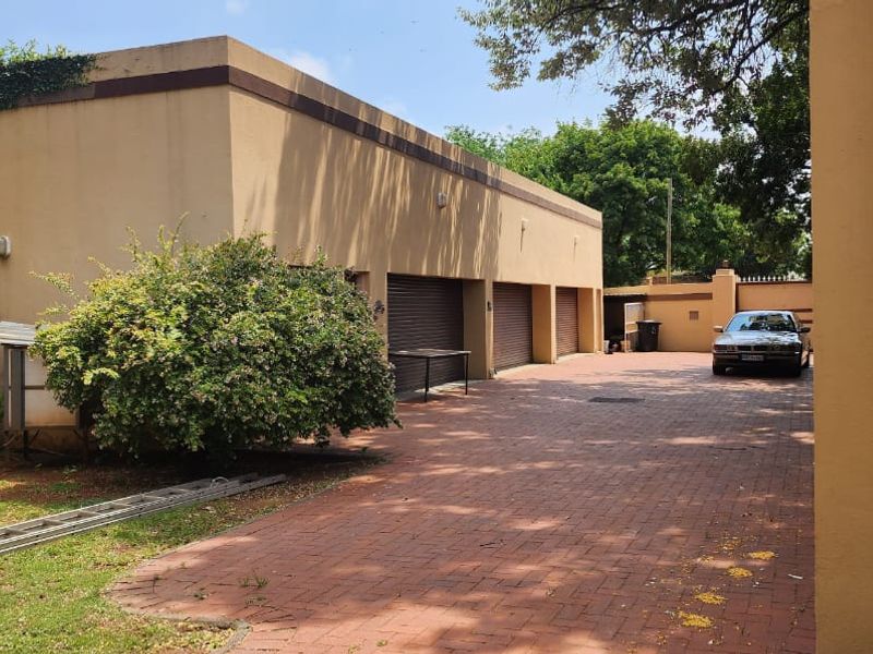 A spacious triple garage with roll-up doors and a large paved driveway area, providing ample parking space.