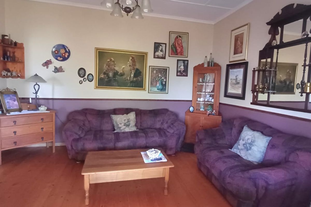 A traditional living room featuring timber flooring and a decorative chair rail, offering a classic foundation for updated interior styling.