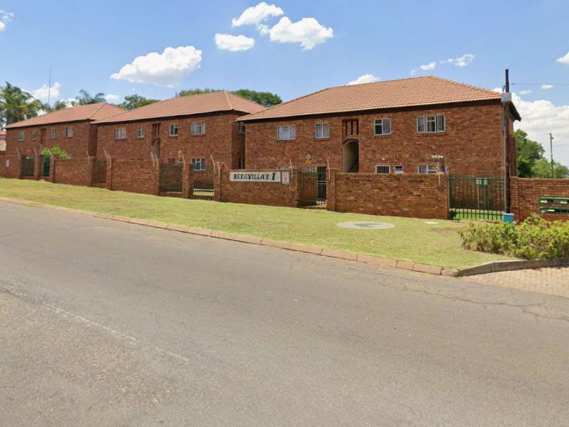 Street view of the Bergvillas apartment complex featuring a classic face brick exterior, tiled roofing, and secure perimeter walling.