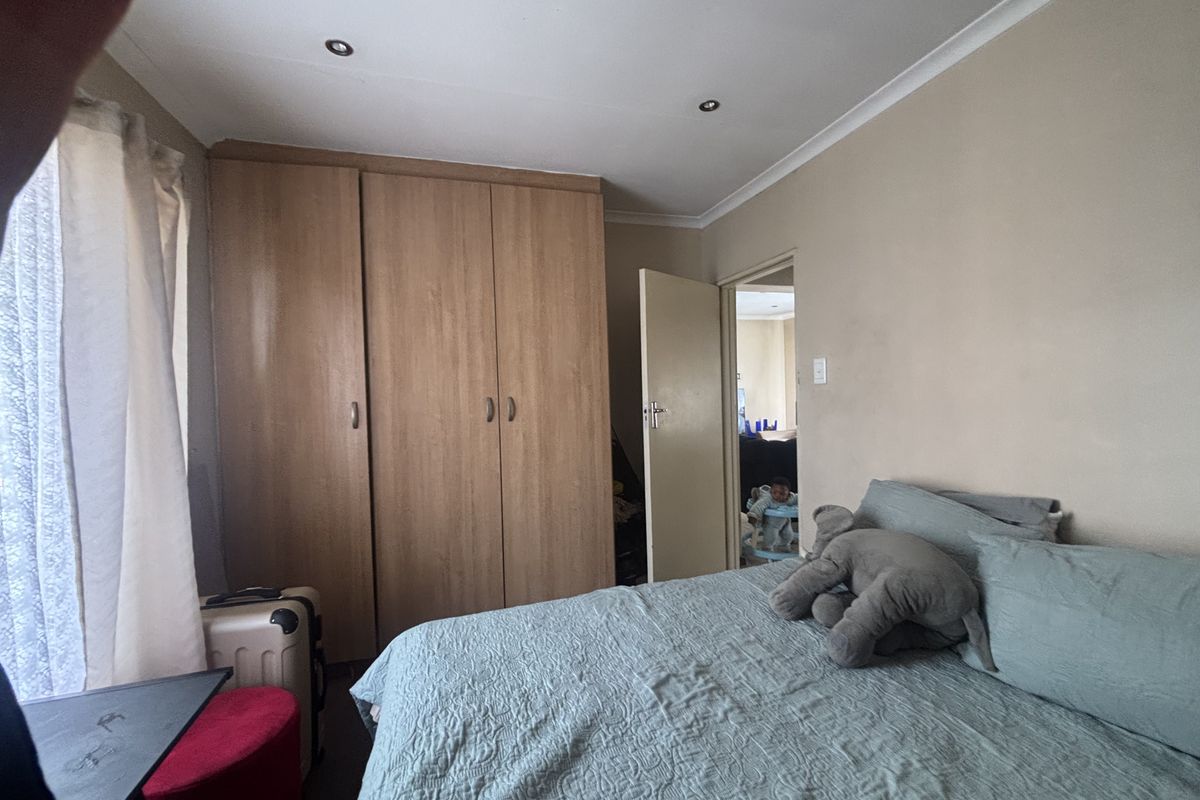 A bedroom featuring built-in wooden cupboards, recessed downlighting, and coved ceiling finishes.