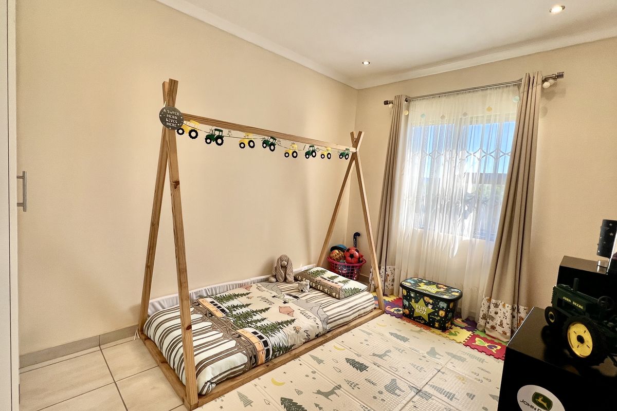 A well-maintained bedroom featuring neutral wall tones, tiled flooring, built-in cupboards, and recessed ceiling lighting.