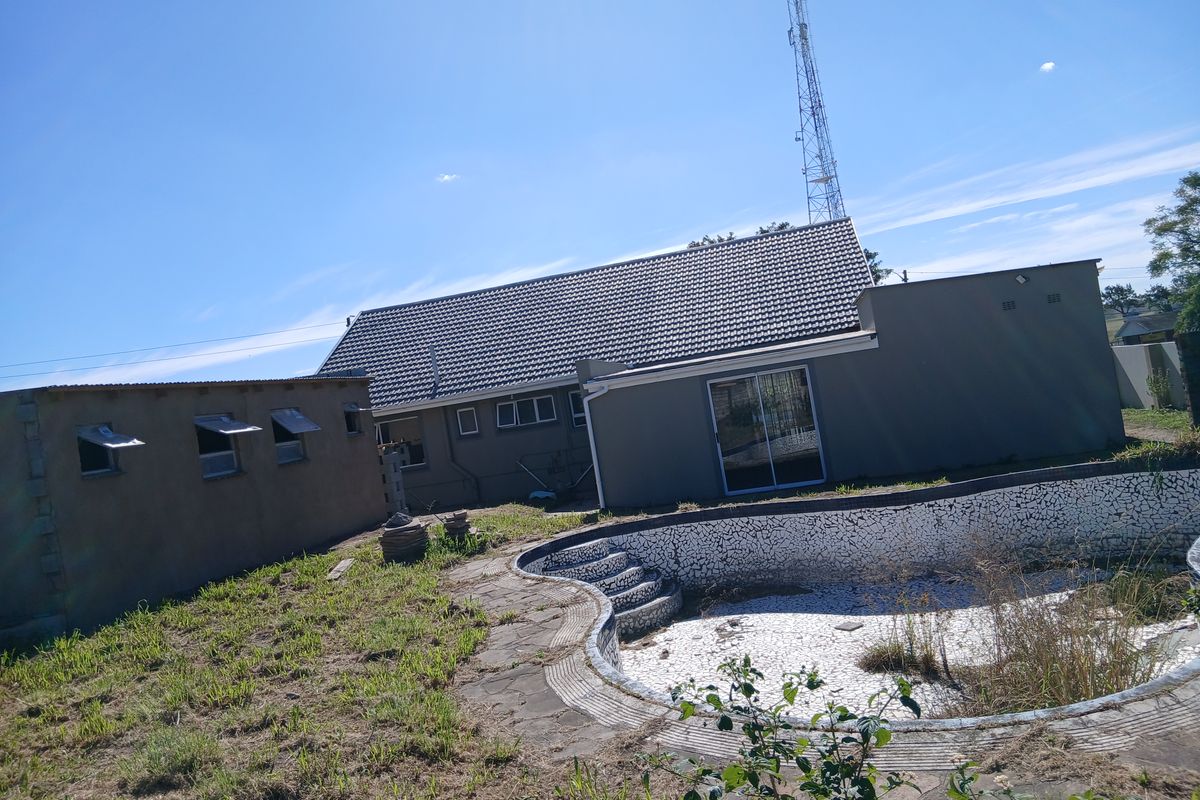 Rear view of the property featuring a tiled roof house, sliding door access, and a swimming pool requiring significant maintenance and repair.