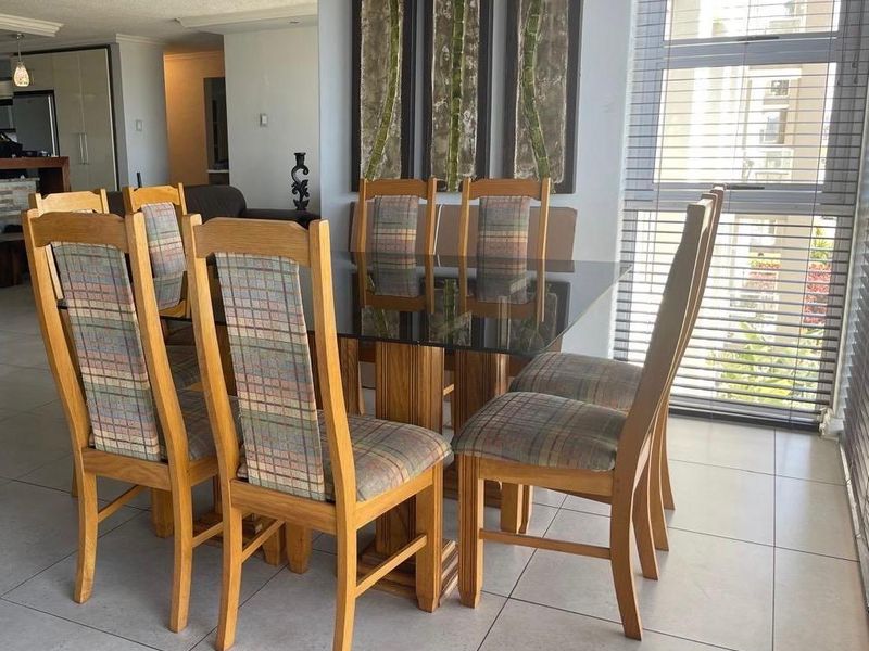 A dining area featuring tiled flooring and large windows with venetian blinds, offering a bright and functional space for meals.