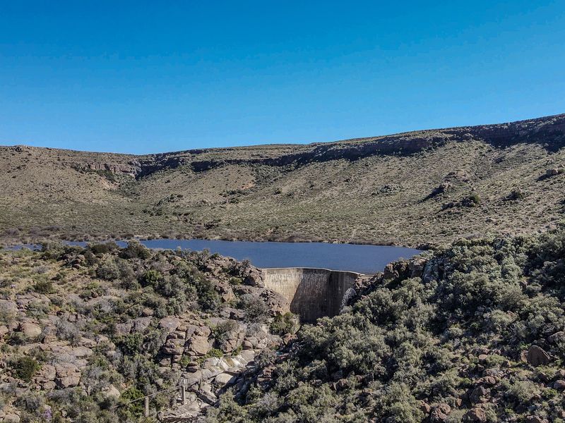 Aerial view of a farm dam and reservoir set within a rugged, natural landscape.