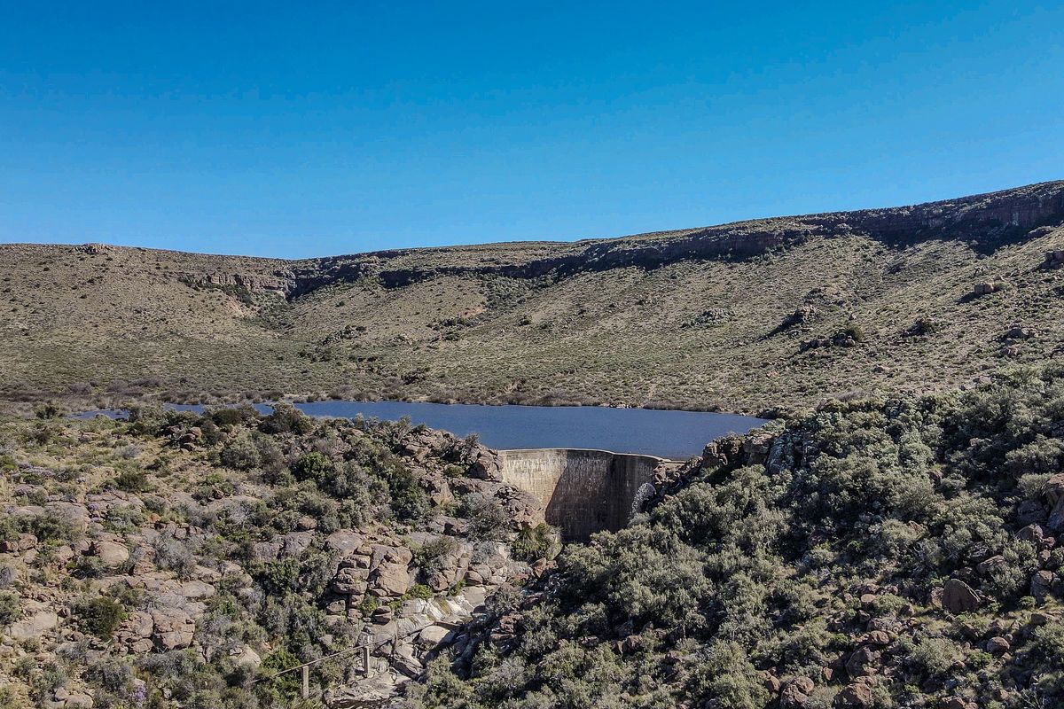 Aerial view of a farm dam and reservoir set within a rugged, natural landscape.