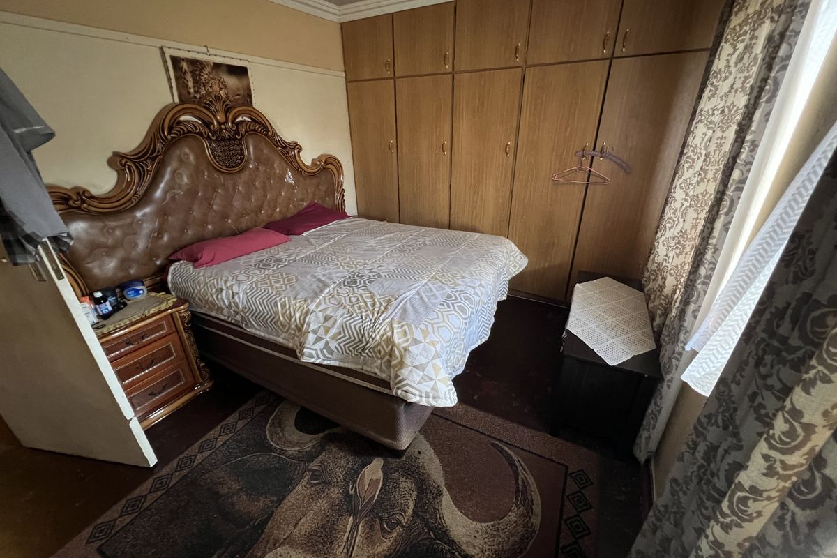 A bedroom featuring built-in wooden cupboards and crown molding, providing functional storage space within the room.