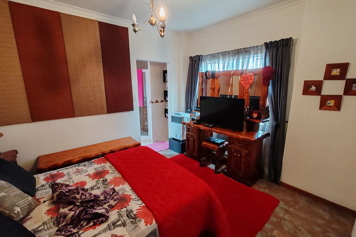 A bedroom featuring tiled flooring and coving, with an adjoining doorway leading to an en-suite or secondary space.