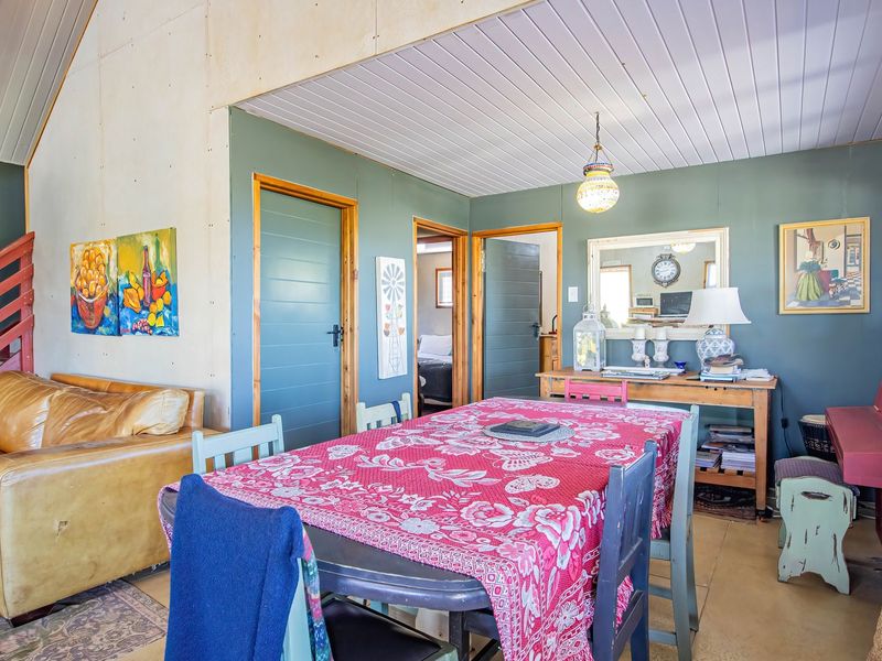 Open plan living and dining area featuring a vaulted ceiling, timber staircase, and direct access to adjacent rooms.