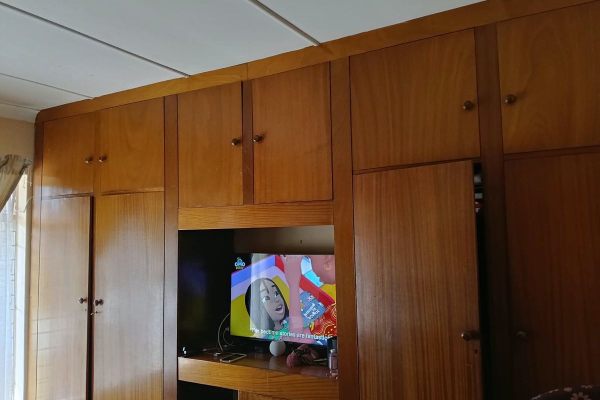 A bedroom featuring extensive floor-to-ceiling built-in wooden cabinetry and wardrobes, providing ample integrated storage space.