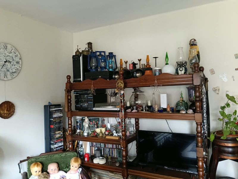 A living room area featuring a large wooden shelving unit used for storage and display.