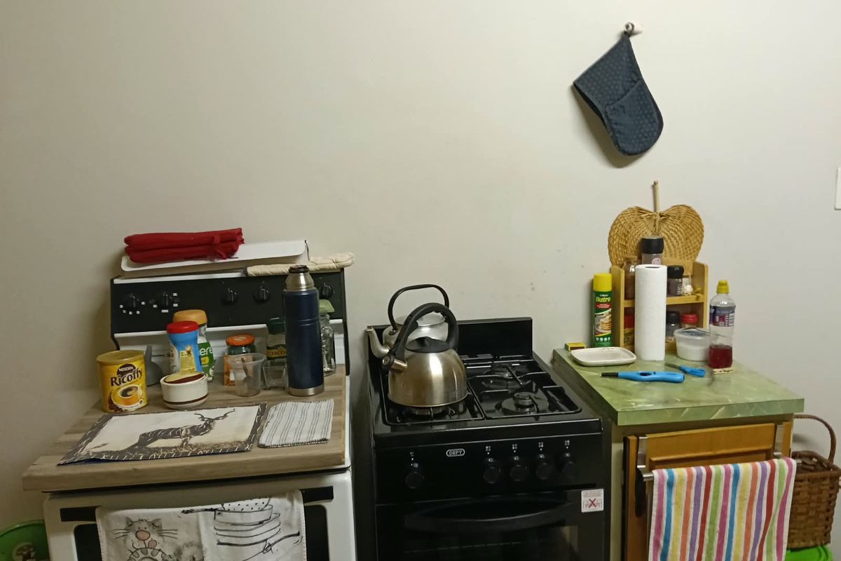 A compact kitchen area featuring a freestanding stove, oven, and laminate countertop workspace.
