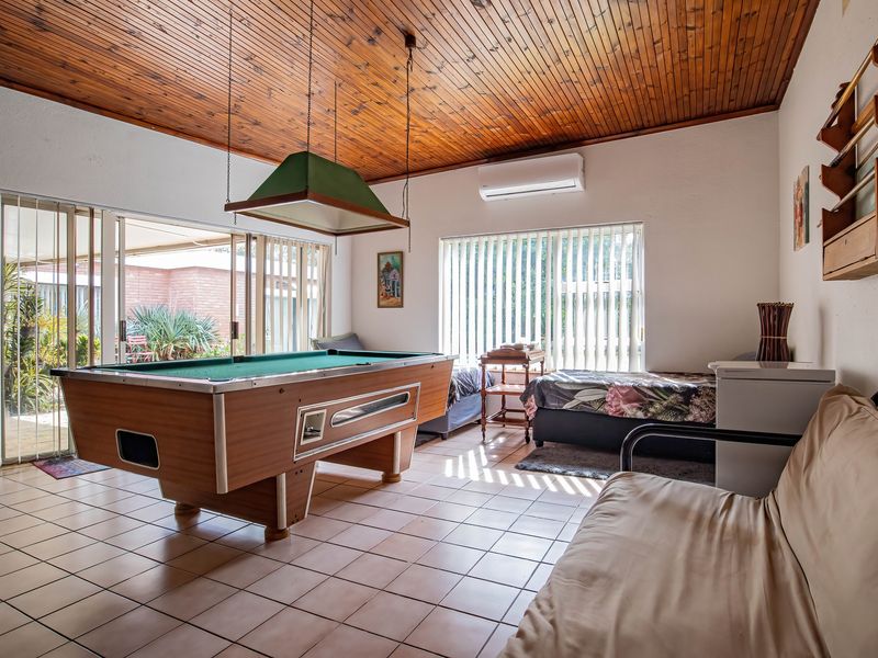 Spacious living area featuring a timber ceiling, tiled floors, and large sliding glass doors providing access to the patio.