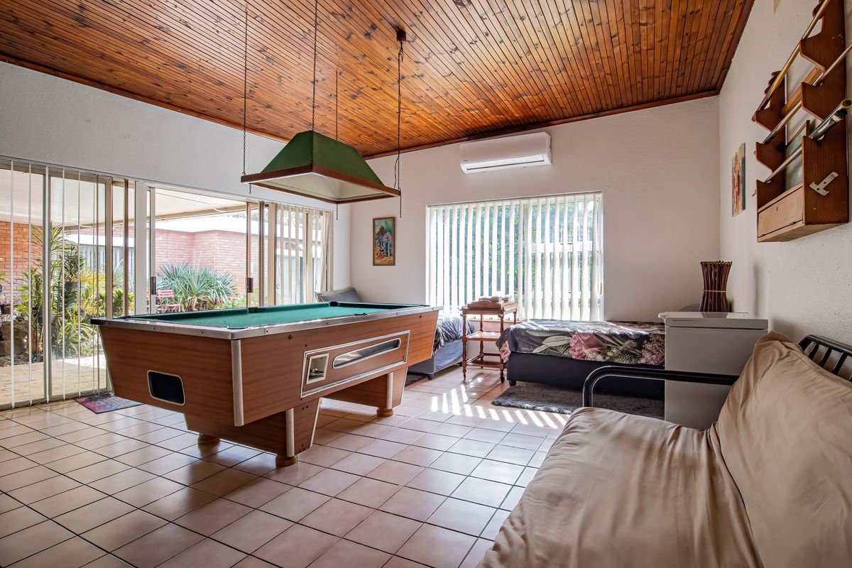 Spacious living area featuring a timber ceiling, tiled floors, and large sliding glass doors providing access to the patio.