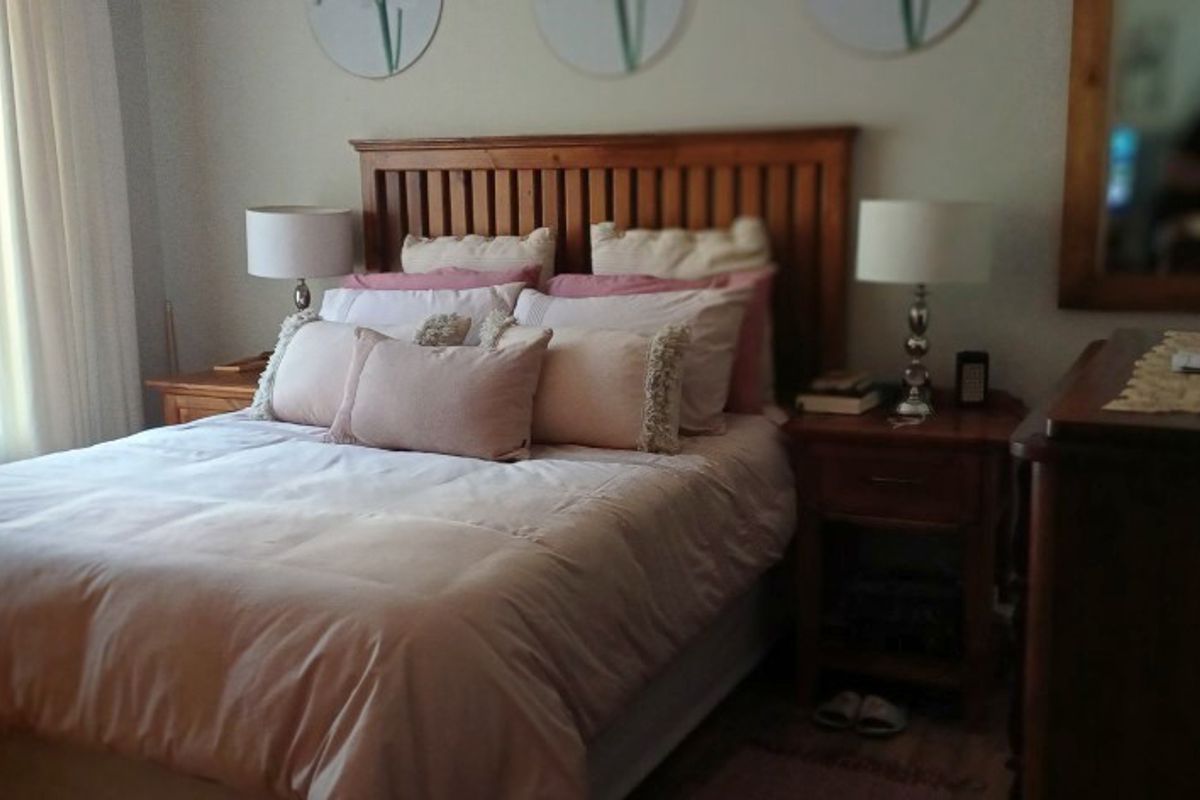 A cozy bedroom featuring a wooden headboard and matching built-in bedside tables, offering a warm and functional sleeping space.
