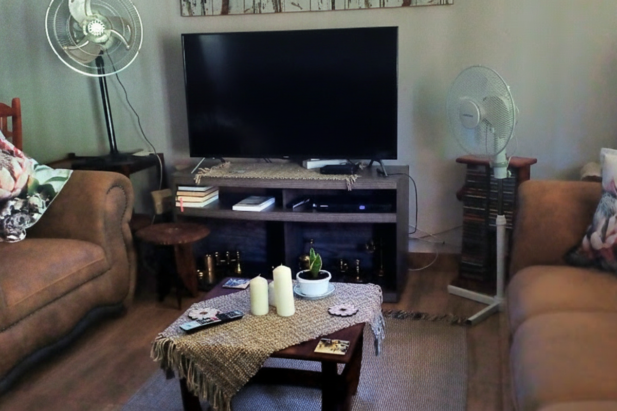 A cozy living room area featuring laminate flooring and a neutral wall finish, providing a comfortable space for relaxation.